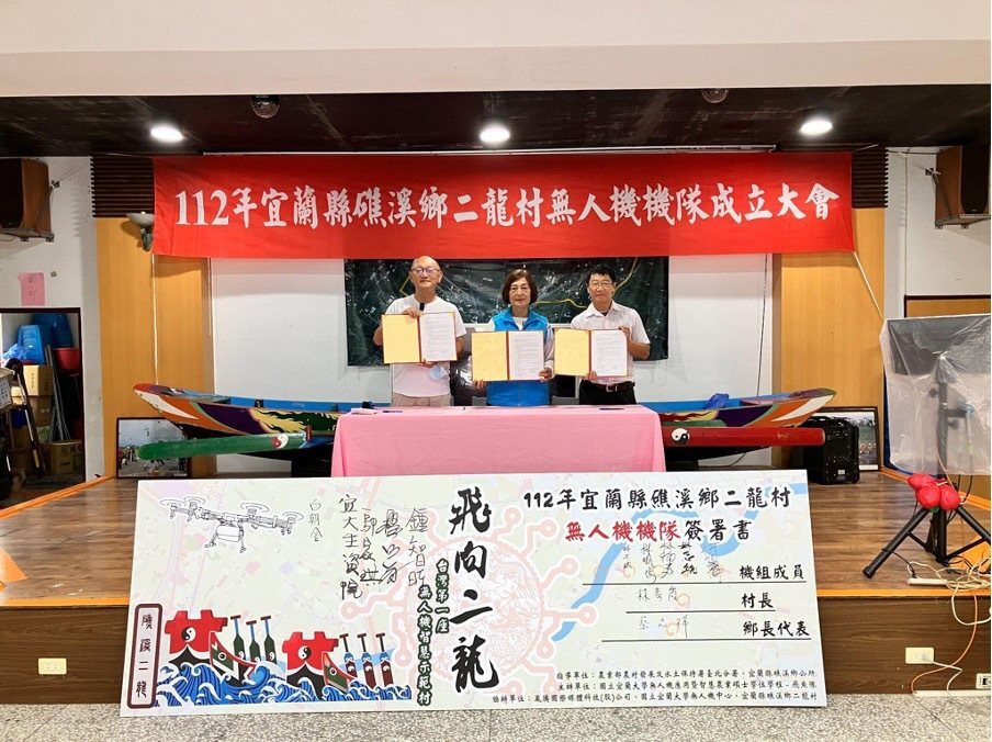 崴騰國際媒體科技董事長侯東崴(左起）、二龍社區發展協會理事長暨二龍村村長林素霞、宜蘭大學無人機應用研究中心主任鍾智昕一同簽署合作。 宜大/提供。